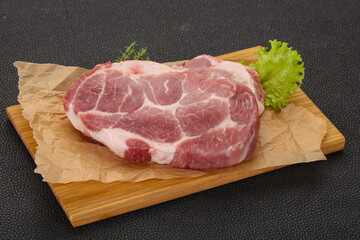 Raw pork steak over wooden board