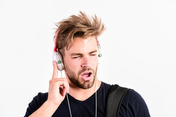 Student handsome guy listening music. Rhythmic melody concept. Download music application. Man tousled hairstyle wear plastic earphones gadget. Enjoy music everywhere you go. Youth music taste