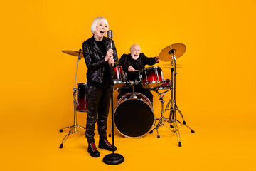Fototapeta premium Portrait of his he her she nice attractive cheerful excited glad grey-haired couple giving live concert having fun performing isolated over bright vivid shine vibrant yellow color background