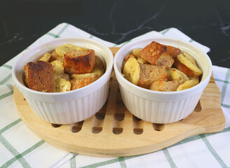 Fresh Baked Two Delectable Banana Bread Pudding in Small Ceramic Bowls on Wooden Breadboard