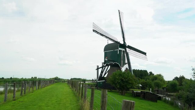 4k Windmill Oukoopse Molen standing in typical Dutch nature with green lands, dutch culture leadinglines.