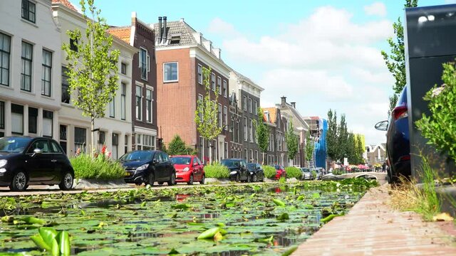 4K Gouda, Netherland Gracht Channel of Gouda City on a Sunny day. typical dutch city green nature low perspective.