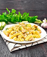 Fusilli with chicken and zucchini in plate on linen napkin