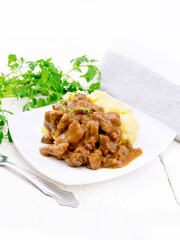 Goulash of beef with mashed potatoes in plate on light wooden board