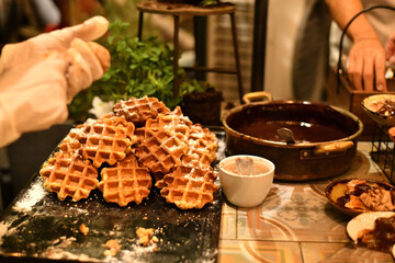 Cooking Belgian waffles with various sauces for dessert during a wedding
