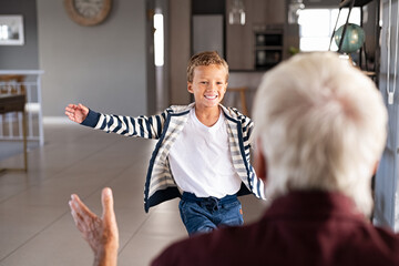 Boy running to hug his senior grandfather