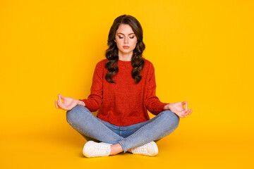 Portrait of her she nice attractive lovely dreamy focused wavy-haired girl sitting in lotus position meditating isolated on bright vivid shine vibrant yellow color background