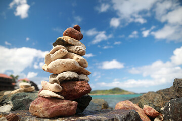 Stones balance on beach and behind hotel resort in blur 