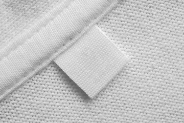 White blank laundry care clothes label on cotton shirt background