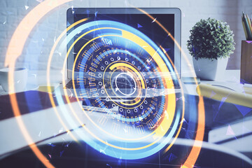 Computer on desktop in office with technology theme hologram. Double exposure. Tech concept.