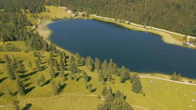 Reveal of the mountain lake in the Bavarian Alps. Aerial view of the so called "Ferchensee" lake, surrounded by small hiking trails and the mountain scenery