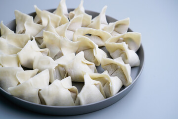 Traditional Chinese food wonton is placed on agray plate.
