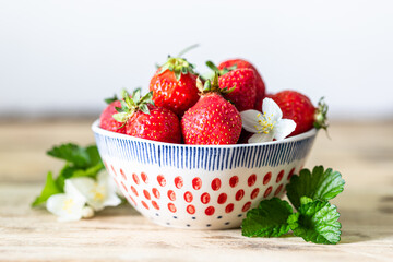 Bowl of strawberries on a wooden background. Copy space