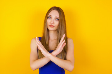 Obraz premium Young beautiful brunette girl wearing casual clothes standing over isolated background. Has rejection angry expression crossing hands doing refusal negative sign.