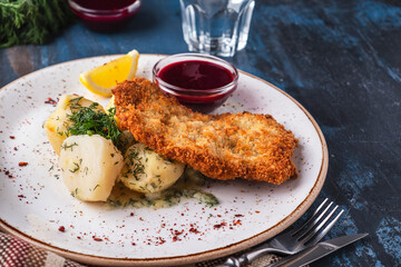 Delicious crust chicken fillet with potato on aplate.