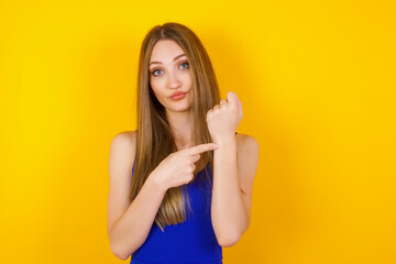 Beautiful young Caucasian woman over isolated background In hurry pointing to watch time,...