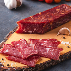 Sliced salami on wooden cutting board. Closeup