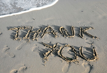 Fototapeta na wymiar text THANK YOU written on the sand of the beach