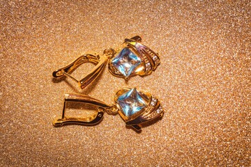 Gold earrings with light blue zirconia