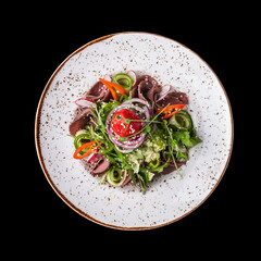 Delicious roast beef salad isolated on a black. Top view