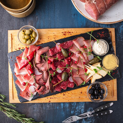 Assorted of ham, salami, sausages and prosciutto on wooden board. Top view