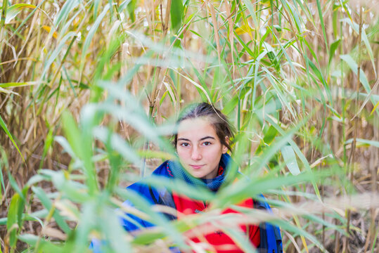 Girl Hiding Behind A Bush In The Woods