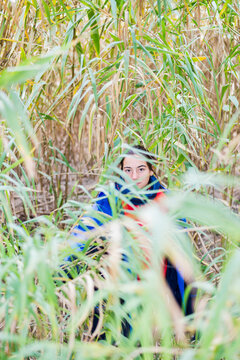 Girl Hiding Behind A Bush In The Woods