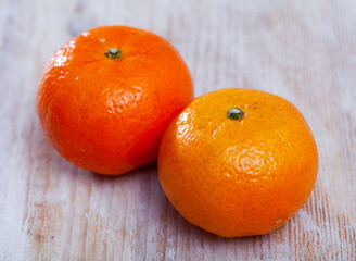 Closeup of two whole ripe organic clementines on wooden background © JackF