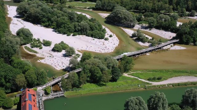 People enjoying this hot summer day at the famous Flaucher Steg at the Isar River, Munich, Germany