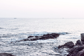 Obraz premium Beautiful rock and waves on the seashore along the coastline.