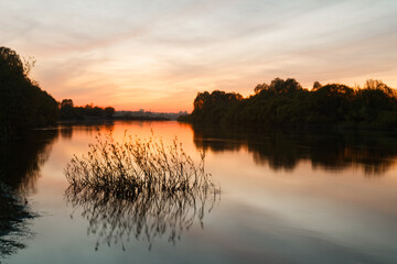 Obraz premium red bloody sunset on the river over water