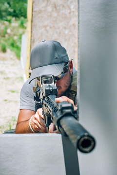 Rifle machine gun combat shooting training from behind and around cover or barricade. Advanced fighting tactical shooting courses on shooting range