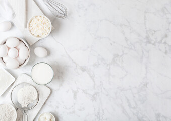 Fototapeta na wymiar Fresh dairy products on white marble background. Glass of milk, bowl of flour, sour cream and cottage cheese and eggs. Steel whisk. Top view. Space for text