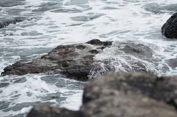 Waves crashing against rocks at the Giant's Causeway, Northern Ireland.