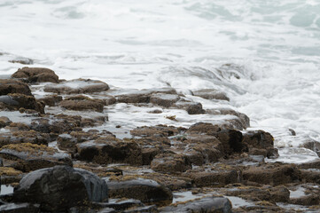 Waves crashing against rocks at the Giant's Causeway, Northern Ireland.