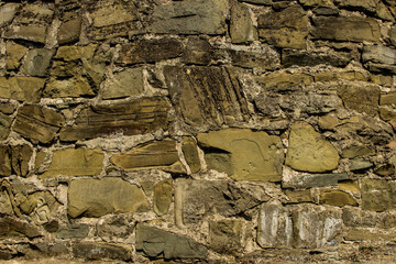 Close-up of masonry on an old stone wall covered with moss.