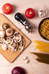raw champignon mushrooms and tomatoes on the rustic wooden surface