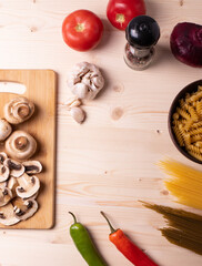 raw champignon mushrooms and tomatoes on the rustic wooden surface