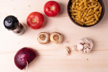 raw champignon mushrooms and tomatoes on the rustic wooden surface