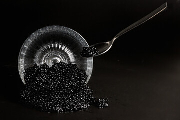 Black sturgeon caviar in a glass jar, on a dark background. Expensive delicacies. Healthy food.