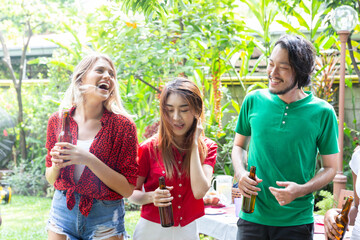 Group of friends having fun and happy in barbecue party at house backyard