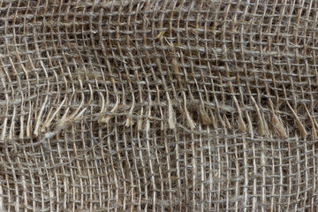 The structure of the threads of a natural burlap fabric close up.