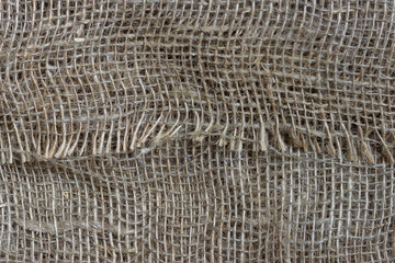The structure of the threads of a natural burlap fabric close up.