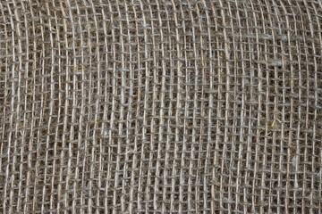 The structure of the threads of a natural burlap fabric close up.