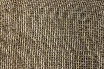 The structure of the threads of a natural burlap fabric close up.