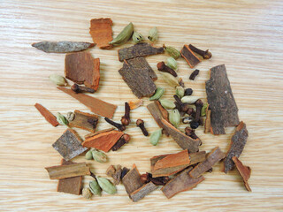 Cardamom, clove and cinnamon in isolated wooden background. 