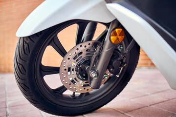 Detail of a motorcycle wheel in the foreground.