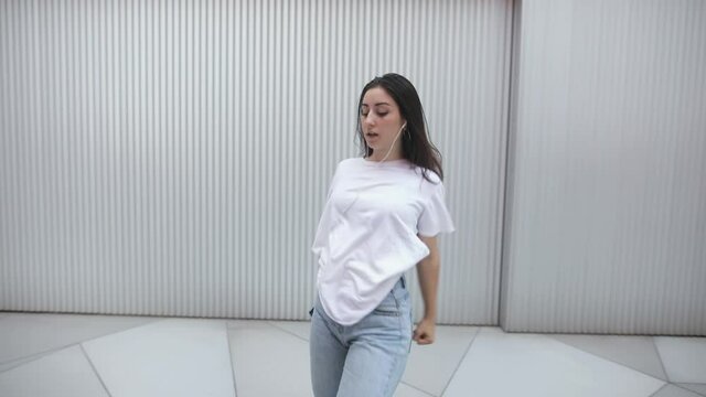 Young woman practicing modern dance on the street in slow motion