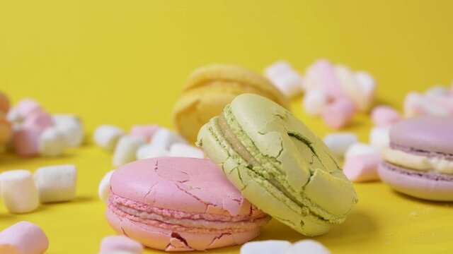 Close up macarone fall and crush on yellow background cookie food dessert destroy sweet color biscuit macaroon french slow motion