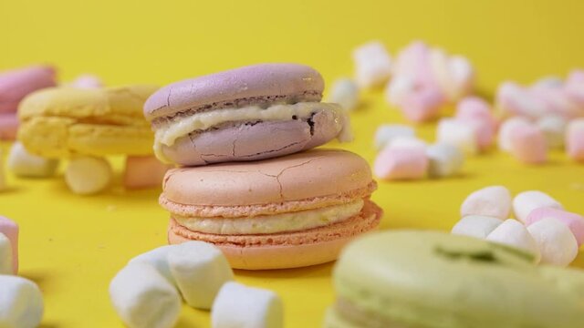 Colorful macarone fall and crush on yellow background cookie food dessert destroy sweet color biscuit macaroon french close up slow motion